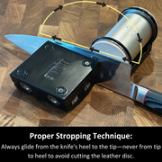 Knife in a HONE Knife Holder beside the Vertical Strop, with arrows showing a heel-to-tip stropping motion